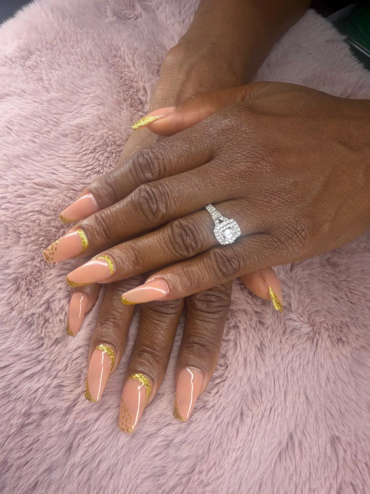 Long peach-colored nails with fine gold accents